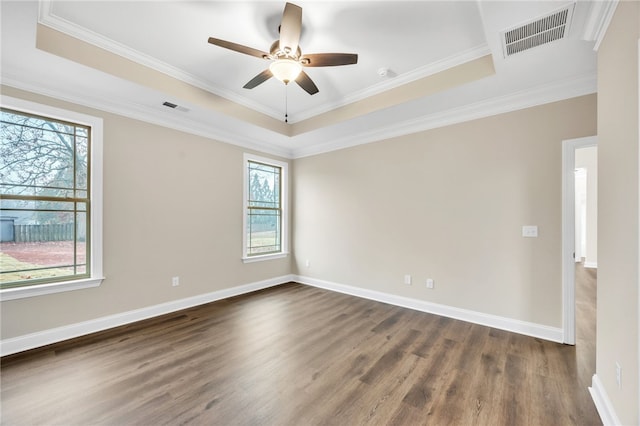 unfurnished room featuring ornamental molding, dark hardwood / wood-style flooring, and a raised ceiling