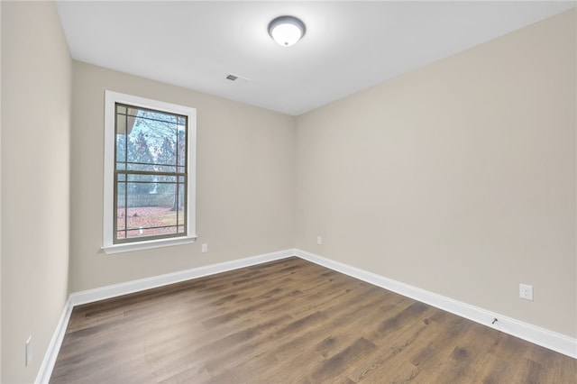 spare room featuring dark wood-type flooring and a healthy amount of sunlight