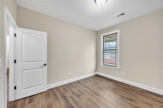 unfurnished room with dark wood-type flooring