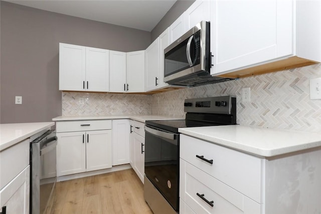 kitchen featuring light hardwood / wood-style floors, white cabinetry, appliances with stainless steel finishes, and tasteful backsplash