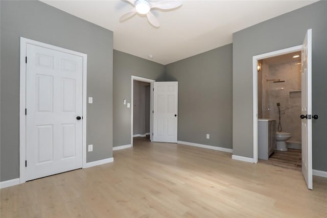 unfurnished bedroom featuring ceiling fan, ensuite bath, and light wood-type flooring