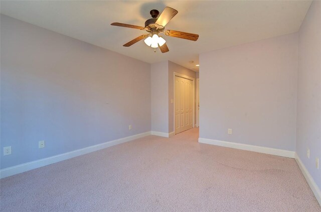 carpeted spare room with ceiling fan