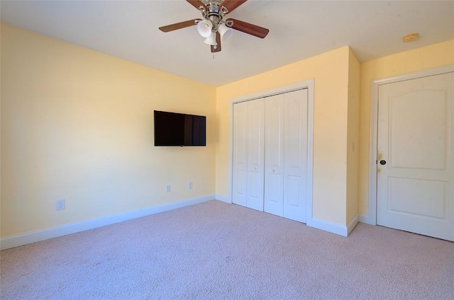 unfurnished bedroom with light carpet, ceiling fan, and a closet