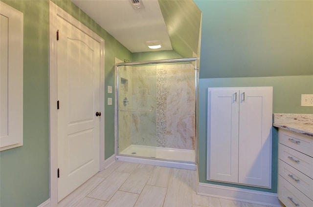 bathroom featuring vanity and a shower with door