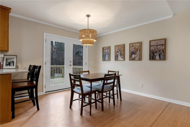 dining room with light hardwood / wood-style flooring, crown molding, and french doors