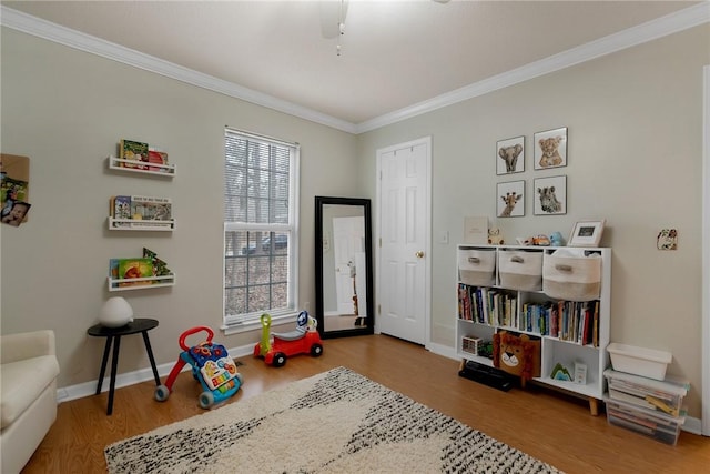 game room with ornamental molding, a healthy amount of sunlight, and wood-type flooring