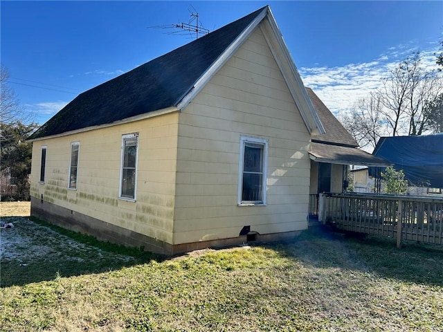 view of side of property with a deck and a lawn