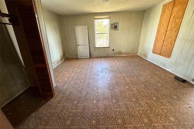 unfurnished bedroom featuring a textured ceiling, electric panel, and a closet