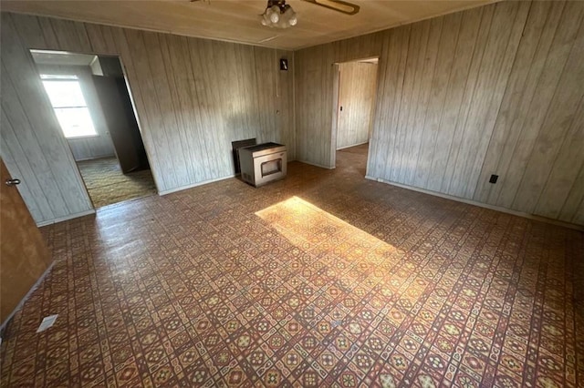 spare room with ceiling fan and wood walls