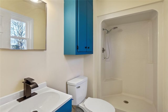 bathroom with vanity, toilet, and a shower