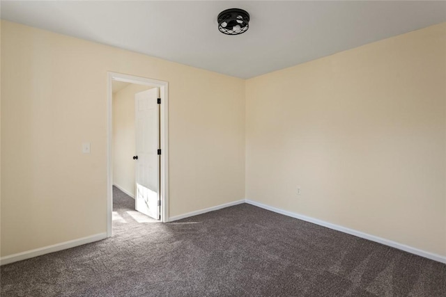 spare room with dark carpet