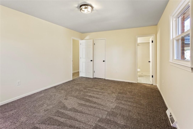 unfurnished bedroom featuring carpet and ensuite bath