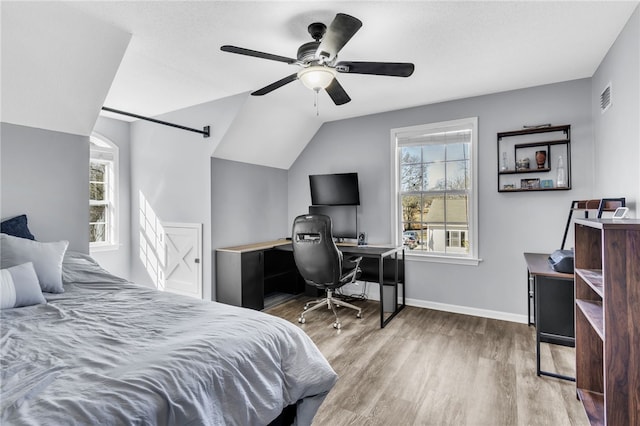 bedroom with ceiling fan, hardwood / wood-style floors, and vaulted ceiling