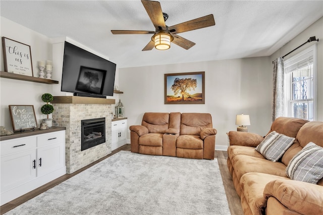 living room featuring ceiling fan, dark wood-type flooring, and a textured ceiling