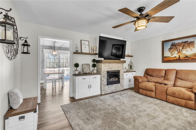 living room with light hardwood / wood-style flooring and ceiling fan