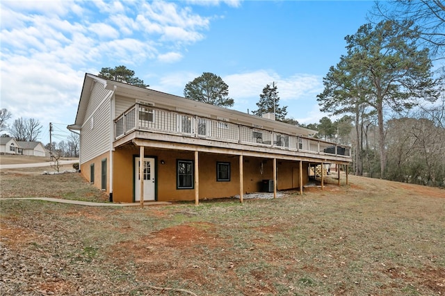 back of property featuring a yard, cooling unit, and a deck