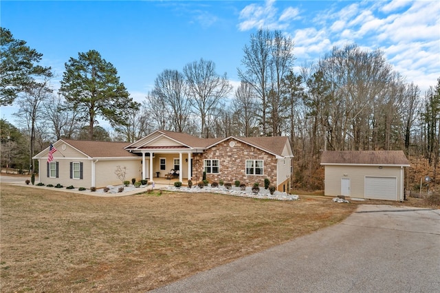 ranch-style home featuring covered porch, a front lawn, and a garage