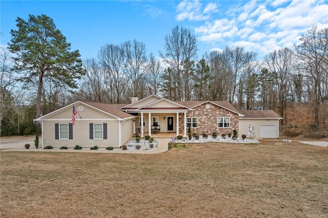 ranch-style home featuring a garage, covered porch, and a front lawn