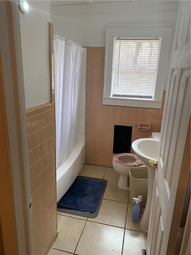 full bathroom featuring tile patterned flooring, shower / bath combination with curtain, sink, tile walls, and toilet