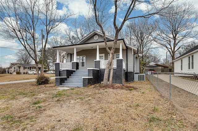 view of front facade featuring covered porch, central AC, and a front yard