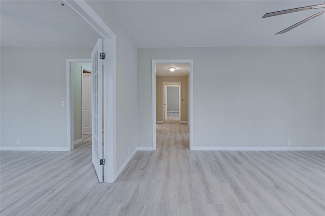 unfurnished room featuring light hardwood / wood-style floors, a textured ceiling, and ceiling fan