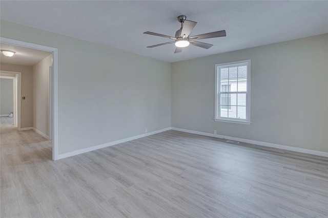 spare room with light hardwood / wood-style floors, a textured ceiling, and ceiling fan