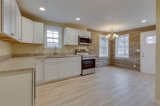 kitchen with sink, white cabinetry, light hardwood / wood-style flooring, and appliances with stainless steel finishes