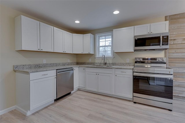 kitchen featuring light hardwood / wood-style floors, sink, white cabinets, and stainless steel appliances