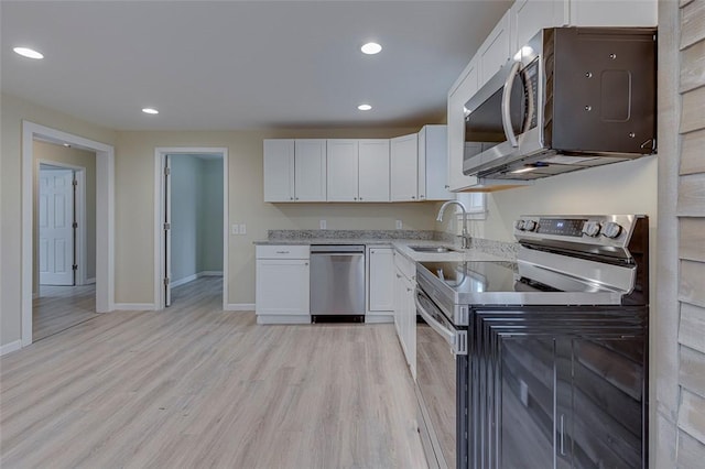 kitchen with light hardwood / wood-style floors, sink, white cabinetry, and stainless steel appliances