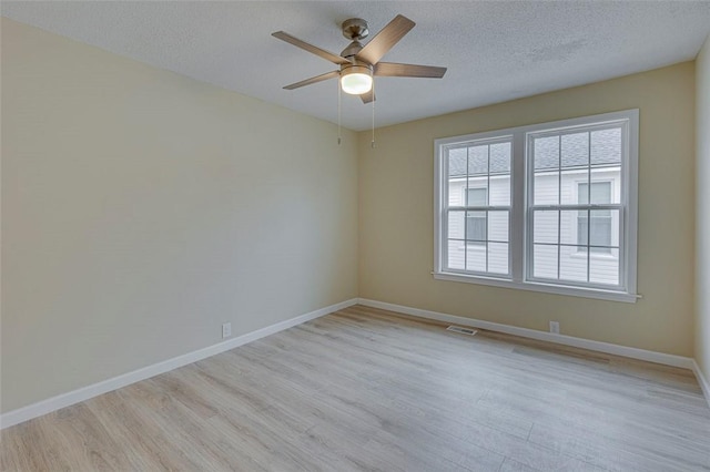 spare room featuring ceiling fan, light hardwood / wood-style flooring, and a textured ceiling