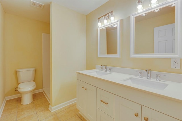 bathroom with toilet, vanity, and tile patterned flooring