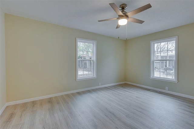 unfurnished room with ceiling fan, light hardwood / wood-style floors, and a textured ceiling