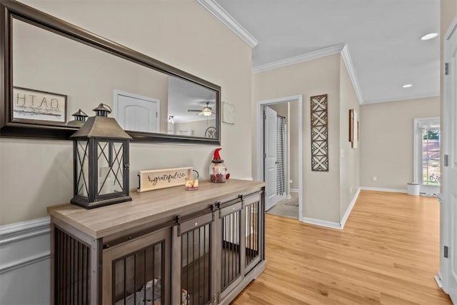 hall featuring ornamental molding and light hardwood / wood-style floors