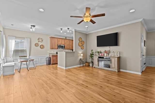 living room with ceiling fan, ornamental molding, and light hardwood / wood-style floors