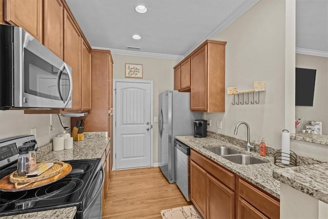 kitchen featuring stainless steel appliances, light hardwood / wood-style floors, sink, light stone counters, and crown molding