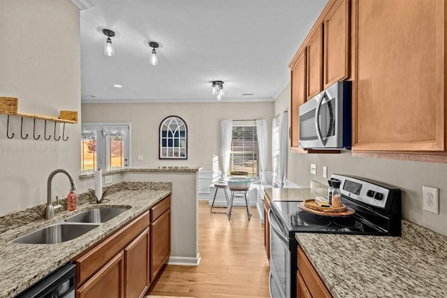 kitchen featuring sink, light stone counters, light wood-type flooring, and stainless steel appliances