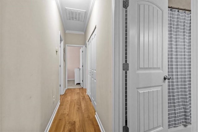 hall with crown molding and light wood-type flooring