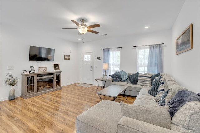 living room with wood-type flooring and ceiling fan