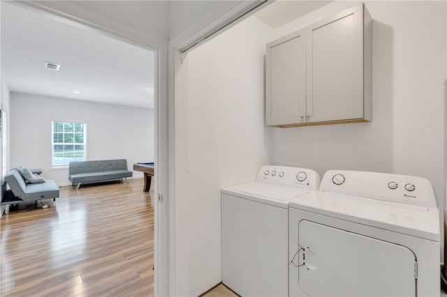 washroom with washer and clothes dryer and light hardwood / wood-style floors