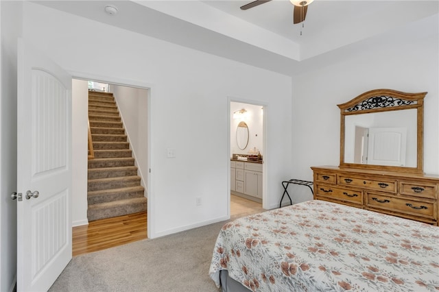 bedroom featuring ceiling fan, connected bathroom, and light colored carpet