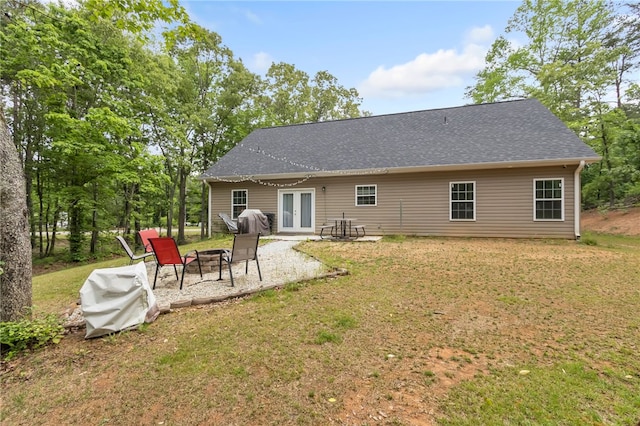 back of property featuring a fire pit, a patio, a lawn, and french doors