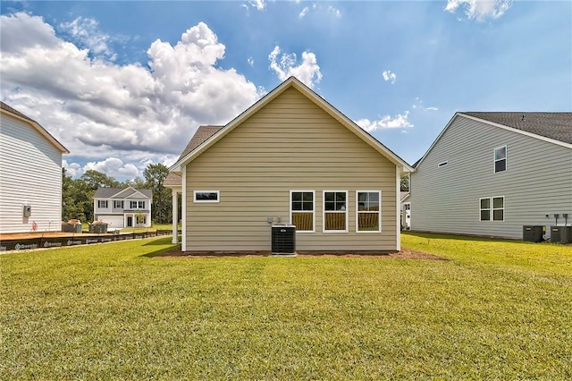 back of property with a yard and central AC