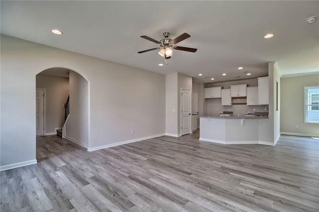 unfurnished living room with light hardwood / wood-style floors and ceiling fan