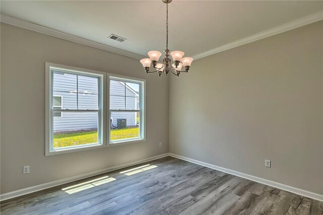 spare room with hardwood / wood-style floors, a chandelier, and ornamental molding