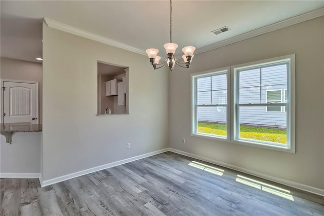 unfurnished dining area with a notable chandelier, light hardwood / wood-style flooring, plenty of natural light, and crown molding