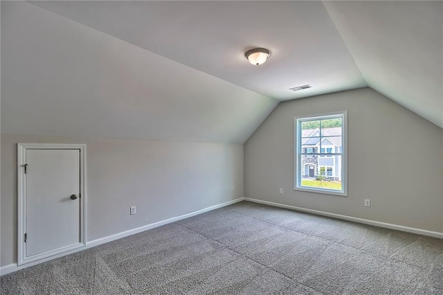 additional living space featuring carpet floors and vaulted ceiling