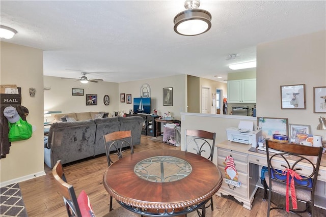 dining room featuring light hardwood / wood-style floors, a textured ceiling, and ceiling fan