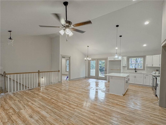 kitchen with decorative light fixtures, white cabinets, light hardwood / wood-style flooring, and a kitchen island