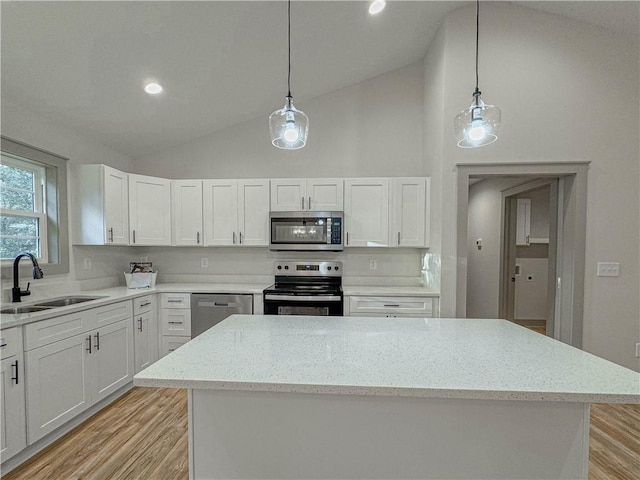 kitchen featuring appliances with stainless steel finishes, white cabinetry, sink, high vaulted ceiling, and pendant lighting