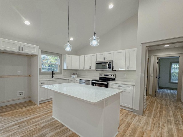 kitchen with sink, white cabinetry, hanging light fixtures, and stainless steel appliances